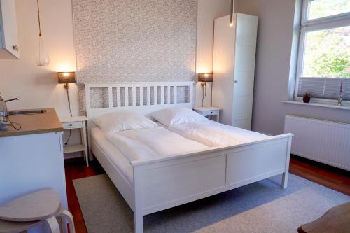 a white bed in a small room with a window at Ferienwohnung LOTTTALEBEN 2 in Timmendorfer Strand