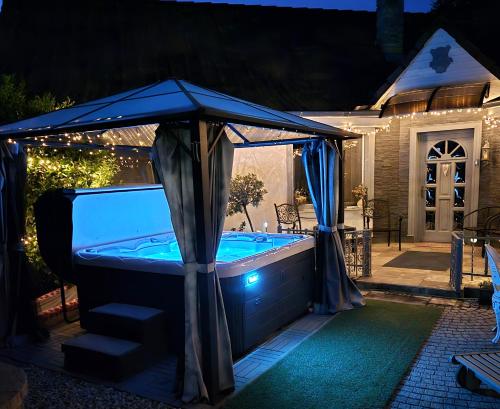 a hot tub with a canopy in a backyard at night at Kristály Pihenőház in Szekszárd