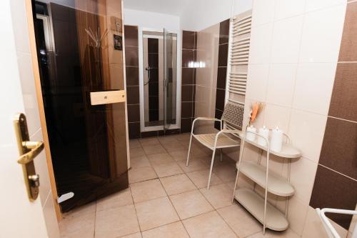 a bathroom with a table and a chair in it at Hotel Pavlov in Karlovy Vary