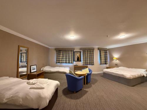 a hotel room with two beds and a desk at Blaby Westfield Hotel in Blaby