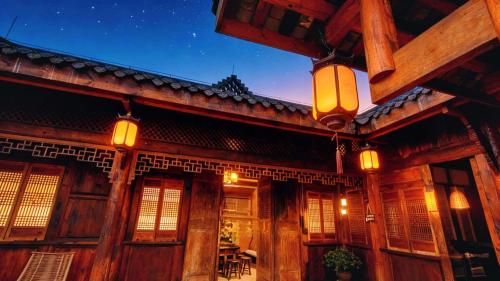 an old wooden building with lights on it at night at Nan Court - Nanyuan,Leshan in Leshan