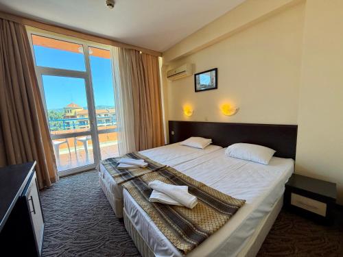 a hotel room with a bed and a large window at Hotel Amaris in Sunny Beach