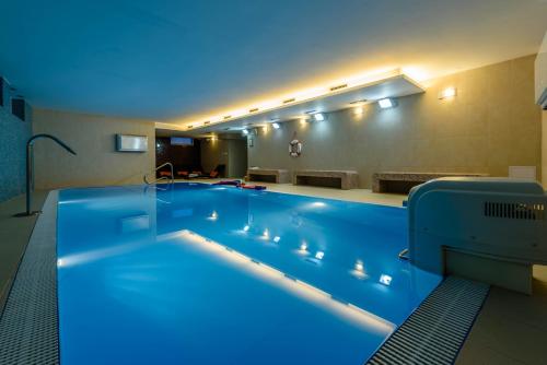 duży basen z niebieskim oświetleniem w pokoju hotelowym w obiekcie Penzión Central Park w Żylinie