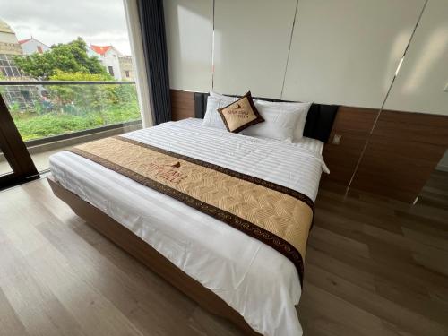 a bedroom with a large bed with a large window at Minhtan2 villa in Dong Hoi