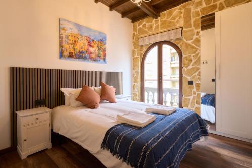 a bedroom with a large bed with a blue blanket at Los Balcones de San Juan in Salamanca