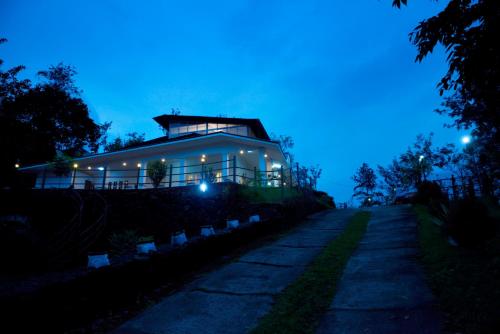 a building at night with a pathway in front of it at Falcon Crest in Vagamon