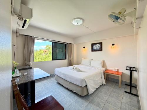 a hotel room with a bed and a window at J Mansion in Ao Nang Beach