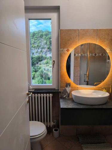 a bathroom with a sink and a window and a toilet at Villa Grazie Mille - Charming Lake Como Escape in Perledo