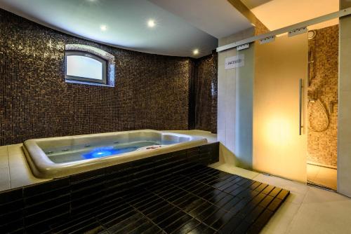a large bathroom with a tub with a window at Penzión Central Park in Žilina