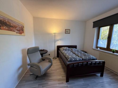 a bedroom with a bed and a chair and a desk at Ruhiges Apartment Meerane in Meerane