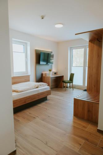 a bedroom with a bed and a desk and a tv at Stay2sleep, Self-Check-In in Dinklage