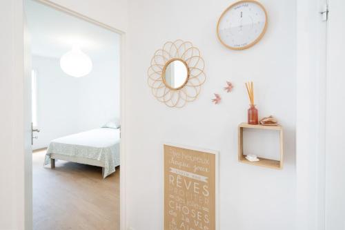 a room with a clock on the wall and a chalkboard at Appartement proche du port in Capbreton