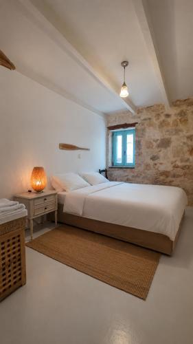 a bedroom with a large bed and a window at Light & Stone Villa, Kefalonia in Lixouri