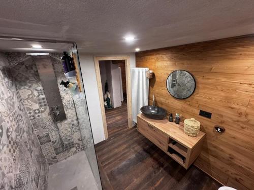 a bathroom with a shower and a sink and a clock at La Caso dal Chiot - Chalet in Elva