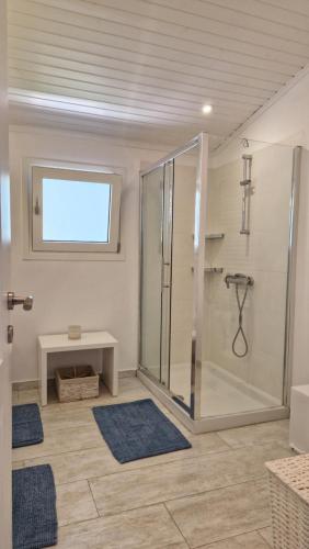 a bathroom with a shower with a bench and a table at Blue Gem Villa in Lefkada