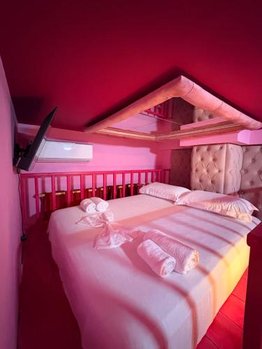a red room with a bed with two towels at Romance Apartments in Sarandë