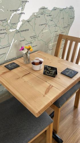 a wooden table with a map on the wall at Flotnar Hús - Newbuild B&B in Keiss