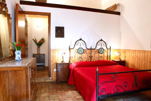 a bedroom with a bed with a red bedspread at Agriturismo Boccadifuoco sul Fiume Alcantara in Motta Camastra