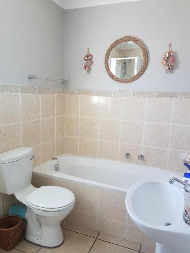 Un baño con inodoro, bañera y lavabo. en Sea Gem, en Big Bay