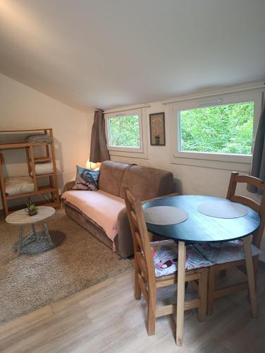 a living room with a couch and a table at studio cosy en pleine forêt in Anduze