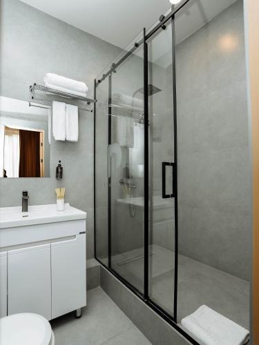 a bathroom with a shower and a toilet and a sink at NOOMA Hotel Frunze in Bishkek