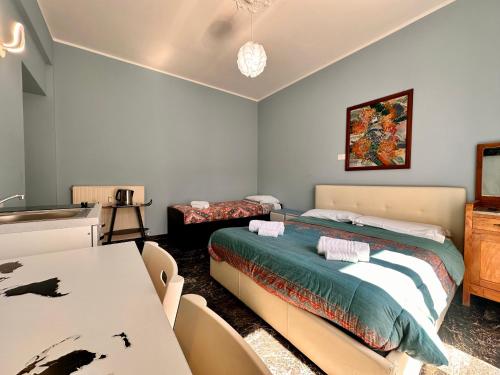 a bedroom with two beds and a table and chairs at La Fenice - Studio Flat in Finale Ligure
