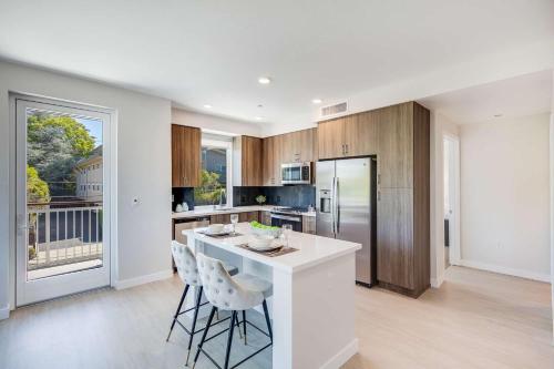 a kitchen with a white island with stools in it at Realm in Menlo Park