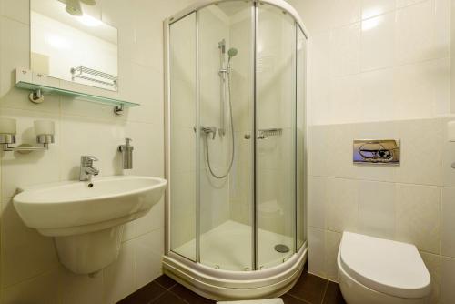 a bathroom with a shower and a sink and a toilet at Penzión Central Park in Žilina