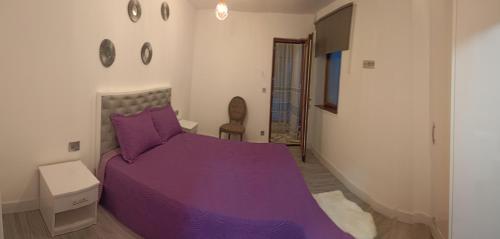 a bedroom with a purple bed in a room at Casa Sheila in Mahmudia
