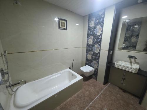 a bathroom with a bath tub and a toilet at The Wayside Inn in Matheran