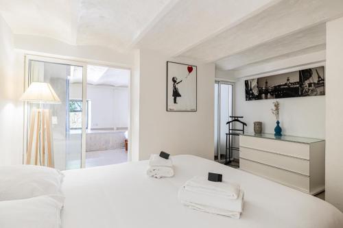 a white bedroom with a large bed with a heart at Cannes Guest House in Cannes