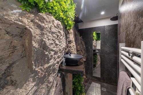 a bathroom with a stone wall with a sink at Cannes Guest House in Cannes