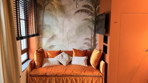 an orange couch in a living room with a wall at Boutique Hotel K7 in Bad Nauheim
