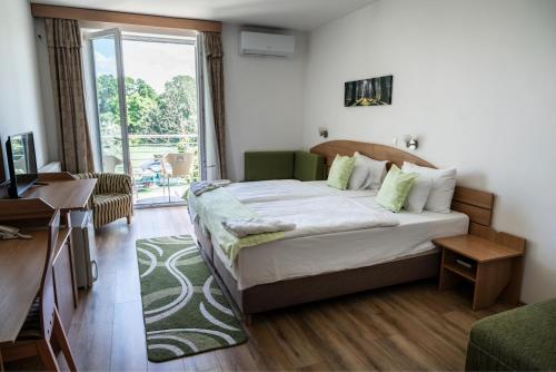 a bedroom with a bed and a large window at Bagoly Fogadó in Gyömrő