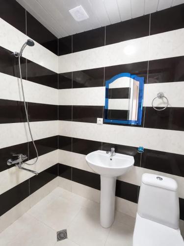 a black and white bathroom with a sink and a toilet at У Царицы in Kobuleti