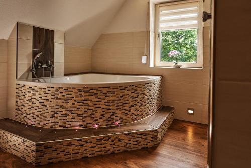 a bath tub in a bathroom with a window at Zimmervermietung Vock in Eschwege