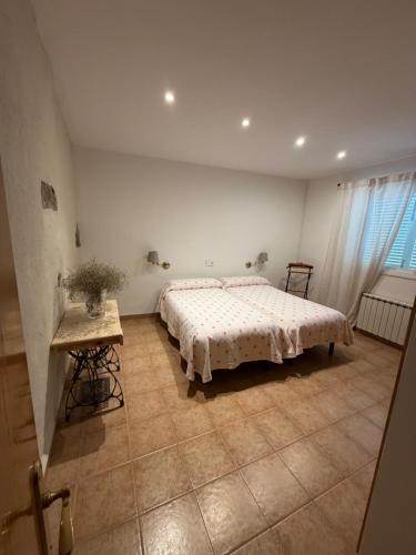 a bedroom with a bed and a table in it at Les Eres de Palouet- Casa de campo con piscina privada in Palouet