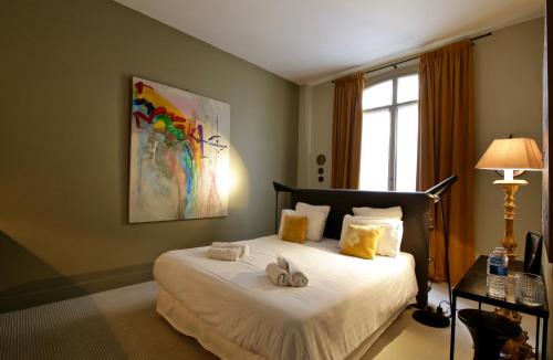 a bedroom with a bed with towels on it at Villa du Square, Luxury Guest House in Paris