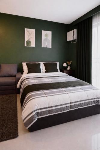 a bedroom with a large bed and a couch at Ocean View Studio Iloilo in Iloilo City