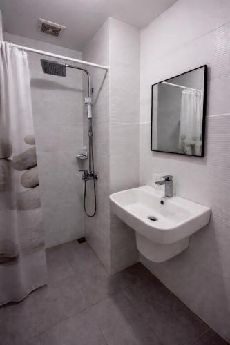 a white bathroom with a sink and a shower at Ocean View Studio Iloilo in Iloilo City