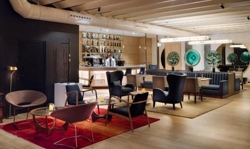 a restaurant with chairs and tables and a bar at H10 Puerta de Alcalá 4 Sup in Madrid