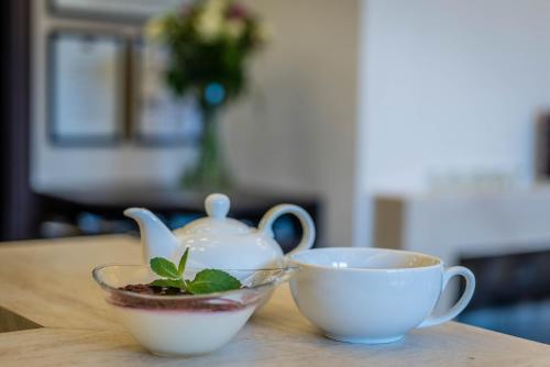 a tea pot and a cup on a table at Penzión Central Park in Žilina