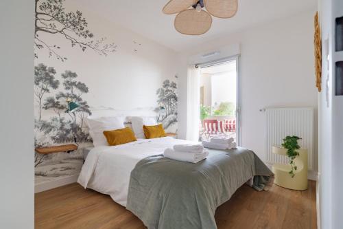 a white bedroom with a bed with towels on it at L'Esplanade - T3 Design avec Parking et Mini-golf in Le Bouscat