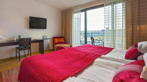 a bedroom with a bed with a red blanket on it at Best Western Plus Time Hotel in Stockholm