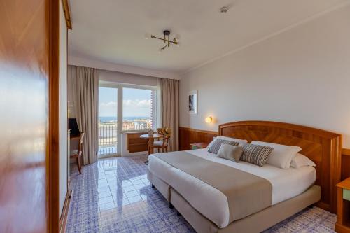 a hotel room with a large bed and a balcony at Grand Hotel Cesare Augusto in Sorrento