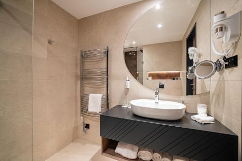 a bathroom with a sink and a mirror at Montello Hotel in Balatonfüred