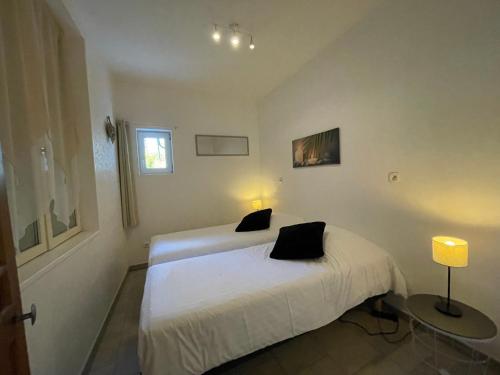 a white bedroom with two beds and a table at Gite CARAMELLE Piscine intérieure privée chauffee toute l annee et spa St Martin in Saint-Martin-lʼHortier