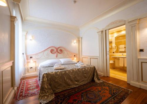 a bedroom with a bed and a rug on the floor at Hotel Colomba d'Oro in Verona