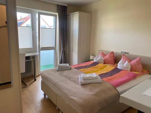 a bedroom with a large bed with towels on it at Hotel Sylvia in Norderney