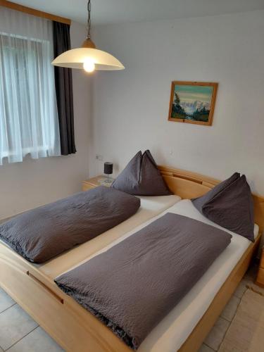 a bedroom with a large bed with brown pillows at Appartementhaus Sabine in Kötschach
